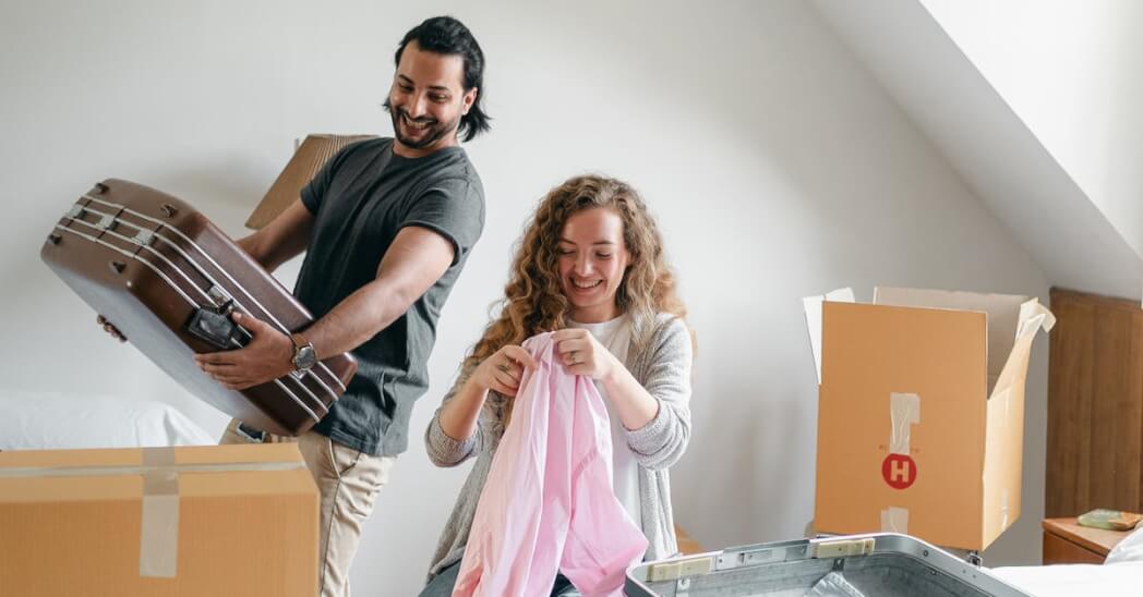 Cheerful couple packing boxes and suitcases